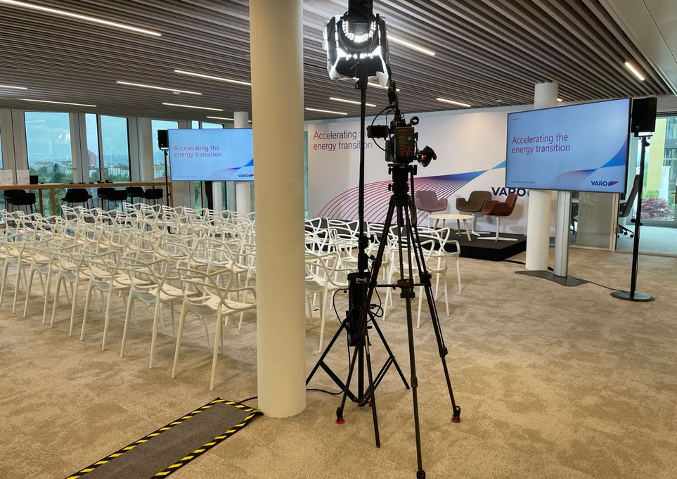 Kamera-Setup vor der Bühne einer Energie-Konferenz mit VARO-Branding und vorbereiteten Sitzplätzen.