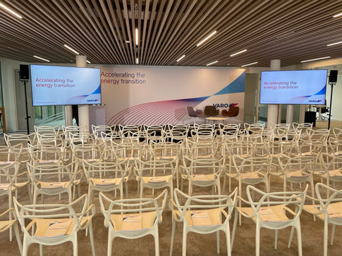 Moderner Konferenzraum mit VARO-Bühne und dem Motto „Accelerating the energy transition“ vor Beginn der Veranstaltung.