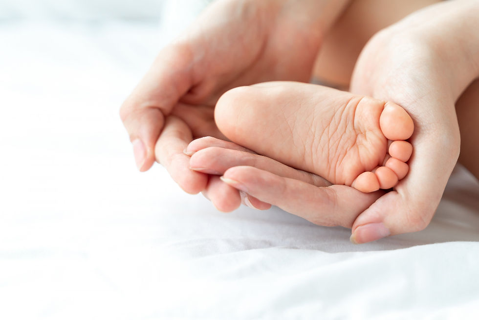 O pé do bebê está nas mãos da mãe