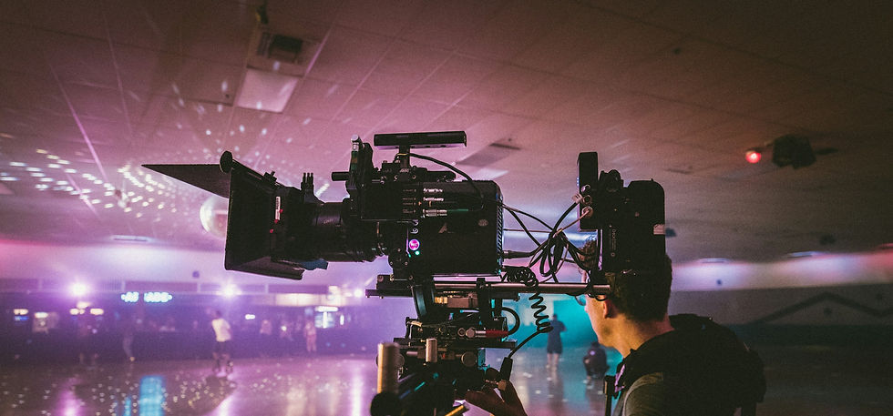 a camera operator stands beside a cinema camera on set of a video production