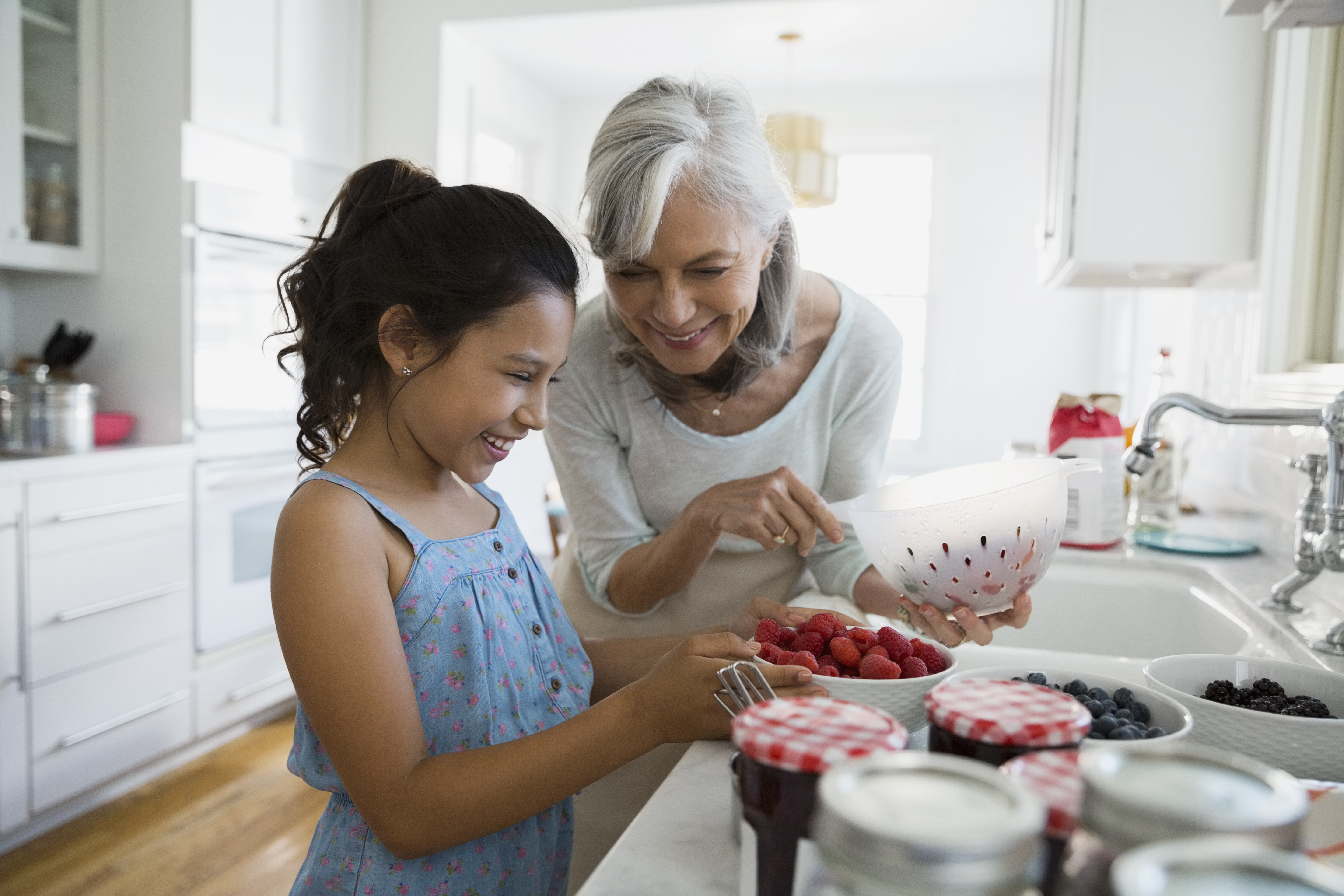 grandmother and granddaughter making jam