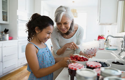 A grandmother and her grandchild prepare jams. They are feeling more connected since starting therapy for generational trauma in Davie, FL with CMC Therapy.