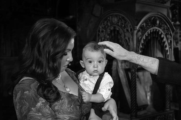 Στιγμές Θρησκευτικής Ευλάβειας.Η φωτογραφία κατά τη διάρκεια της βάπτισης αποτυπώνει τις ιερές στιγμές και τη σοβαρότητα της τελετής.