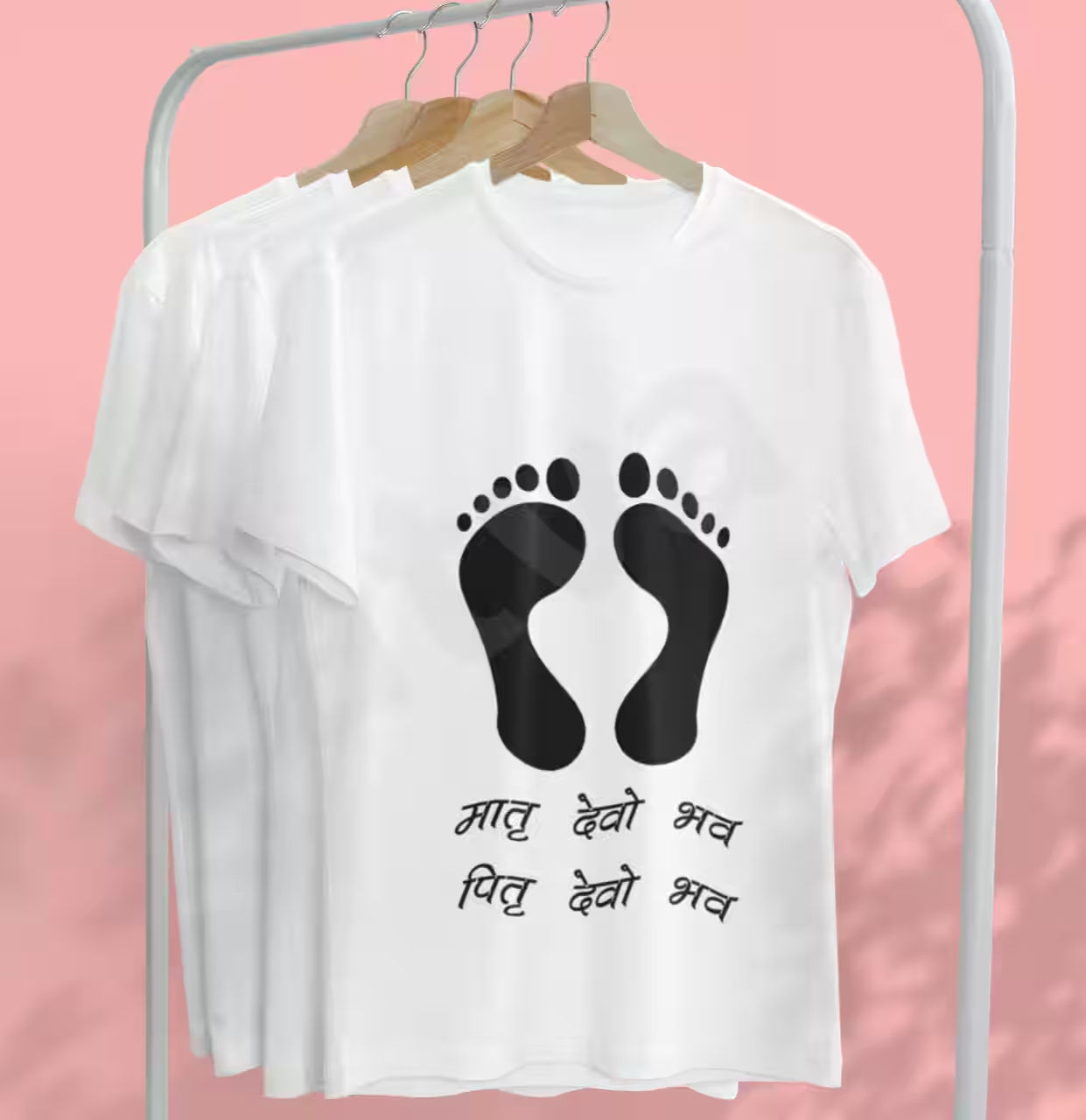 A white graphic T-shirt with feet design and Sanskrit verse Matru Devo Bhava, Pitru Devo Bhava.