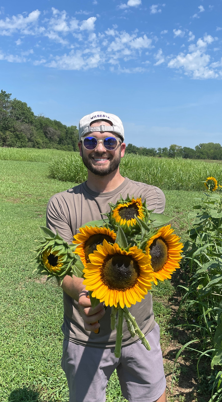 A man holding bunch of sunflowers.