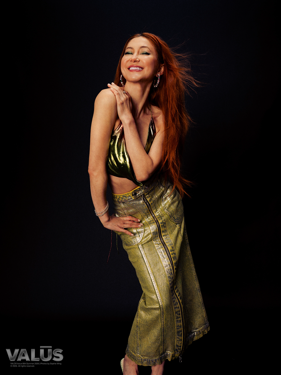 KIMIKO wears a top by AREA, a skirt by ECKHAUS LATTA, shoes and earrings by MOSCHINO, and bangles and ring by LANORE FINE JEWELRY
