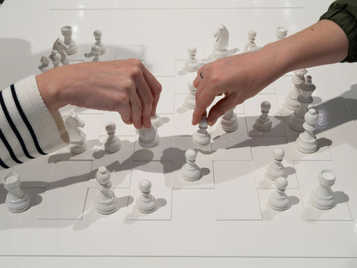 Mão estratégica movendo peça de xadrez em close-up, simbolizando a lógica da proteção patrimonial para empresários e a antecipação de riscos.