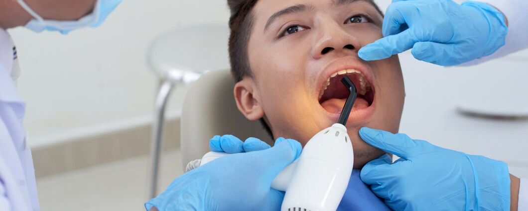 dentist-holding-ultraviolet-light-asian-male-patient-s-tooth-treatment_1098-20343.jpg