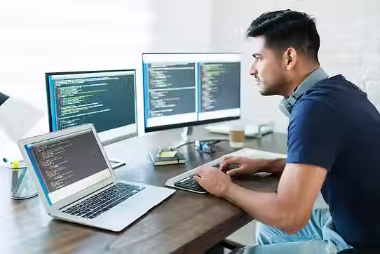 side-view-attractive-hispanic-software-developer-programming-using-computer-while-working-