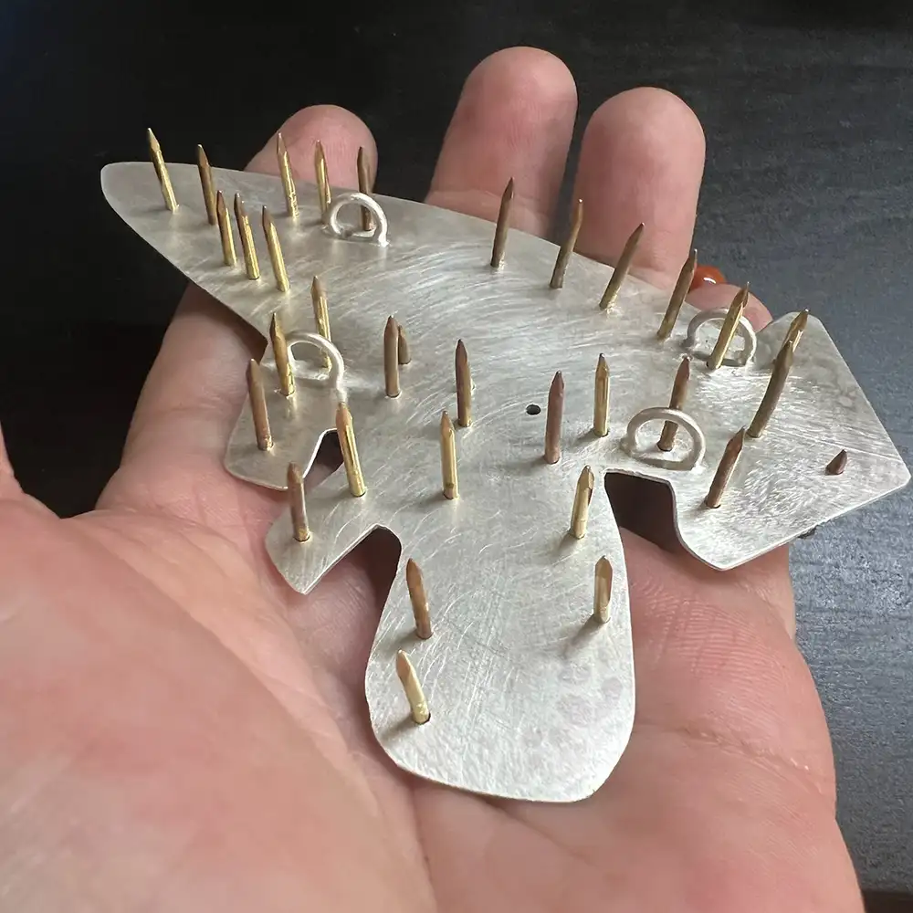 Back of ray gun pendant in process with rivets