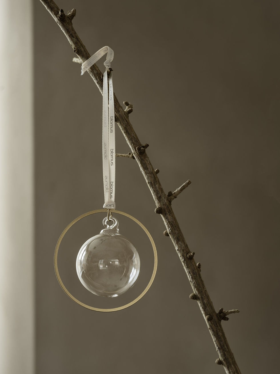 Runder Weihnachtsschmuck mit einer grauen Glaskugel für den Tannenbaum mit einem Seidenband.