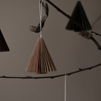 Ein sandfarbenes, faltbares Papierornament für den Tannenbaum in Form eines Tannenbaums.