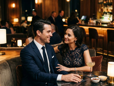 A woman and man sitting in a nice lounge, look each other in the eyes and smile at each other admiringly.