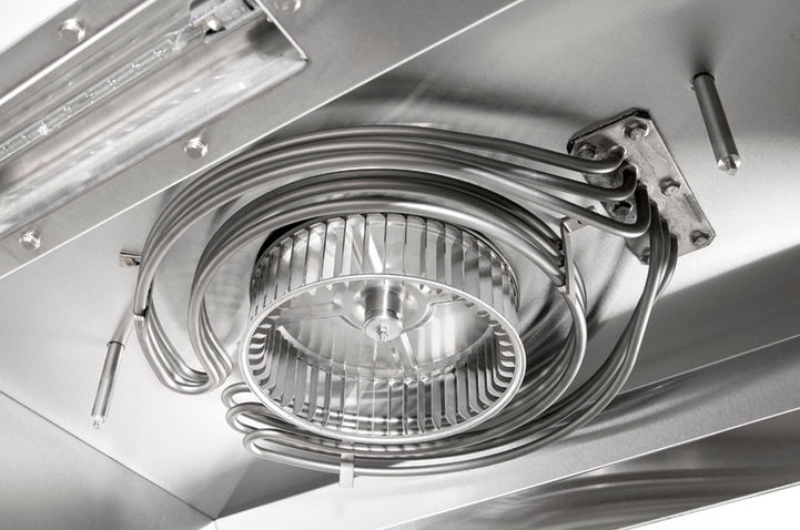 Industrial fan and silver pipes inside a metallic machine component detail.