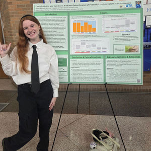 myself standing next to a poster presentation of my research.