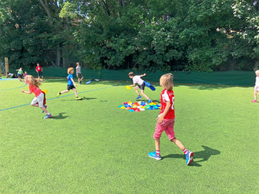 Children running on green field. Sunny day outdoor activity. Omega Sportz.