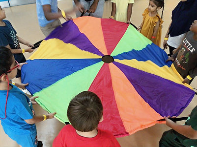 Children holding a colorful parachute, playing and enjoying a fun activity together.