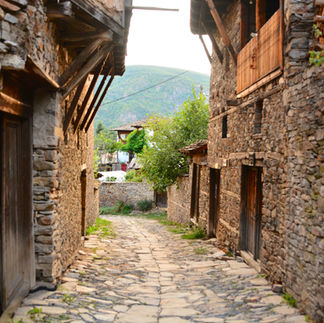 stone huts on the side of a cobble stone road