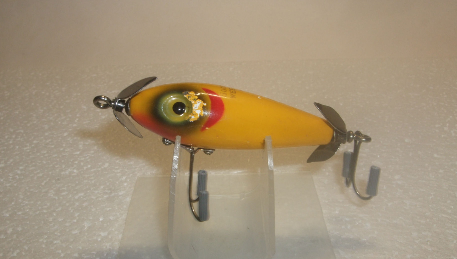 Vintage yellow South Bend Wee Nippee fishing lure with red head markings, dual metal propellers