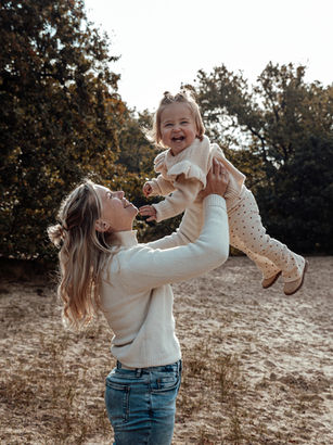 Gezin tijdens familiefotoshoot in de natuur bij in Rotterdam met ouders en kinderen in warme, natuurlijke lichtomstandigheden
