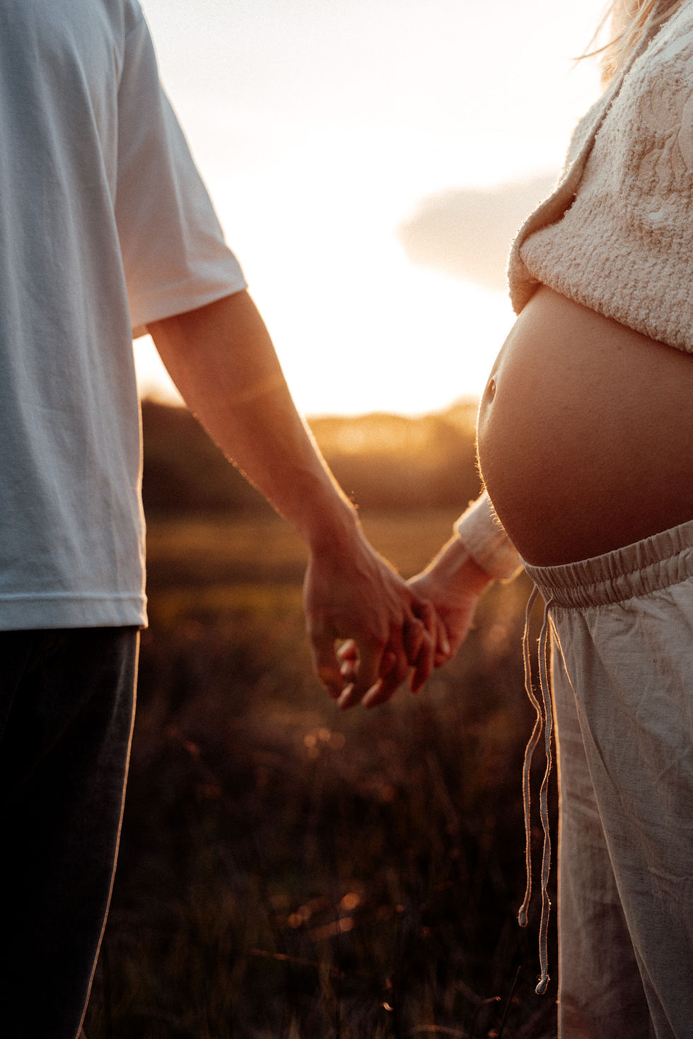 Zwangerschapsshoot met een subtiele babybuik tijdens golden hour.