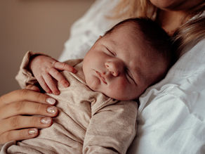 Lifestyle newborn shoot thuis in Dordrecht en Rotterdam met moeder die haar pasgeboren baby liefdevol vasthoudt in natuurlijk licht
