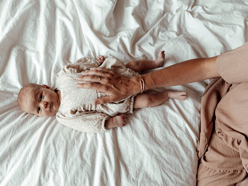 Wakkere pasgeboren baby kijkt nieuwsgierig naar moeder tijdens een newborn fotoshoot thuis.