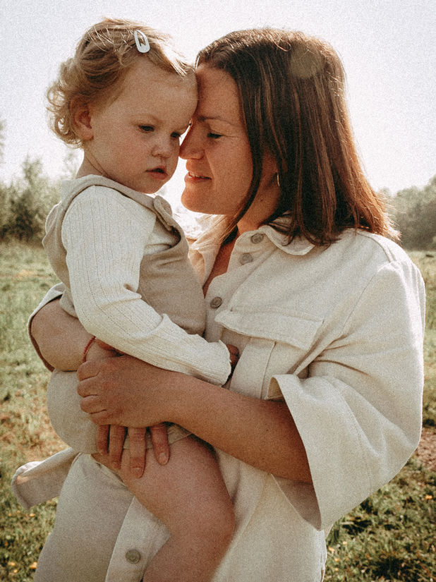 Gezin tijdens familiefotoshoot in de natuur bij in Rotterdam met ouders en kinderen in warme, natuurlijke lichtomstandigheden