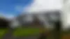 Centred grand villa façade in Auckland with pitched roof timber cladding and manicured lawn, representing Wilkran’s heritage builds
