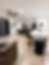 Modern interior facility with sofa, kitchen island, dining table, and mirrors.