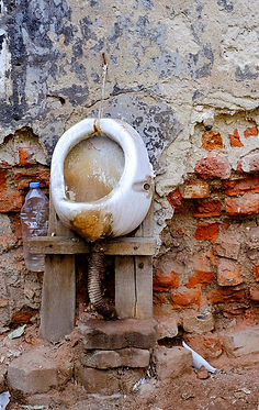 verdreckte Toilette an bröckelnder Ziegelwand