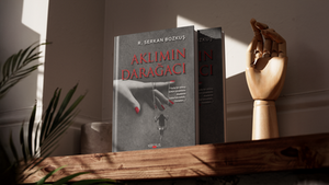 İnsan psikolojisinin karanlık, tekinsiz ve dramatik yönlerini sarsıcı bir görsel hiyerarşiyle ele alan derinlikli bir kurgudur. Gri tonlarındaki dokulu arka plan üzerinde yükselen monokrom el illüstrasyonu ve bu elin parmaklarından sarkan salıncakta sallanan yalnız kadın figürü, eserin ismindeki sıkışmışlık ve darağacı sembolizmini sanatsal bir boyutta dışa vurmaktadır. Kadının ojesindeki kırmızı detaylar ile üst bölüme konumlandırılan serif karakterli, ince gölgeli ve kan kırmızısı "Aklımın Darağacı" başlığı arasında güçlü bir kontrast ritmi kurulmuş; sağ taraftaki tırnak içi editoryal alıntı metni ise okuyucuyu doğrudan kitabın felsefi evrenine davet etmektedir. En alt kısımdaki "Kerasus" yayınevi logosunun dengeli yerleşimiyle bütünlüğü sağlanan bu mizanpaj, editoryal titizliği ve dramatik estetiği bir potada eriterek portfolyonuz için akılda kalıcı, çarpıcı ve profesyonel bir kitap tasarımı örneği sunmaktadır.
