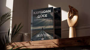 Yasin Şen’in Kaygıdan Güce adlı eseri için gerçekleştirilen kitap dizgi-mizanpajı ve kapak tasarımı, bireysel gelişim ve psikolojik dönüşüm temasının tekinsiz ama umut dolu atmosferini sinematik bir görsel dille ele alan iddialı bir projedir. Kapak mizanpajının fonunu kaplayan dramatik, fırtınalı gökyüzü ve bulutların arasından süzülen ilahi ışık hüzmeleri içsel aydınlanmayı simgelerken; uçsuz bucaksız, ıssız bir yolda tek başına yürüyen insan figürü "Kaygıyla başa çıkma ve içsel güç" mottosunu harika bir biçimde somutlaştırmaktadır. Üst haznede yükselen beyaz, kalın sans-serif "KAYGIDAN GÜCE" başlığı ile yolun zeminine asimetrik bir perspektifle giydirilen yazar ismi arasındaki tipografik kurgu, dizgi süreçlerindeki yaratıcı titizliği gözler önüne sermektedir. En alttaki kurumsal "KDY" amblemiyle hiyerarşik dengesi tamamlanan bu dinamik çalışma, portfolyonuz için akılda kalıcı, çağdaş ve vuruş gücü yüksek bir kapak mizanpajı örneği sunmaktadır.