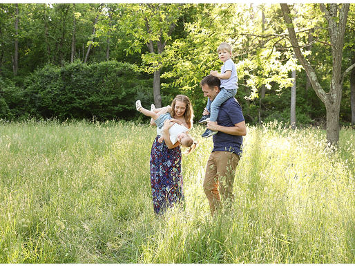 family playing in tall grass field