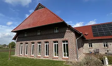 Sanierter Altbau mit neuen dreifach verglasten Holzfenstern und wärmegedämmter Fassade nach energetischer Modernisierung