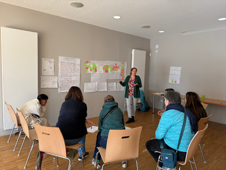 Séance d’intelligence collective en association : un groupe en atelier collaboratif, animé devant des affiches remplies de notes et post‑its, travaillant sur la vision, les enjeux et les priorités du collectif.