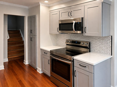 Modern small kitchen with gray shaker cabinets, slim black cabinet pulls, and stainless st