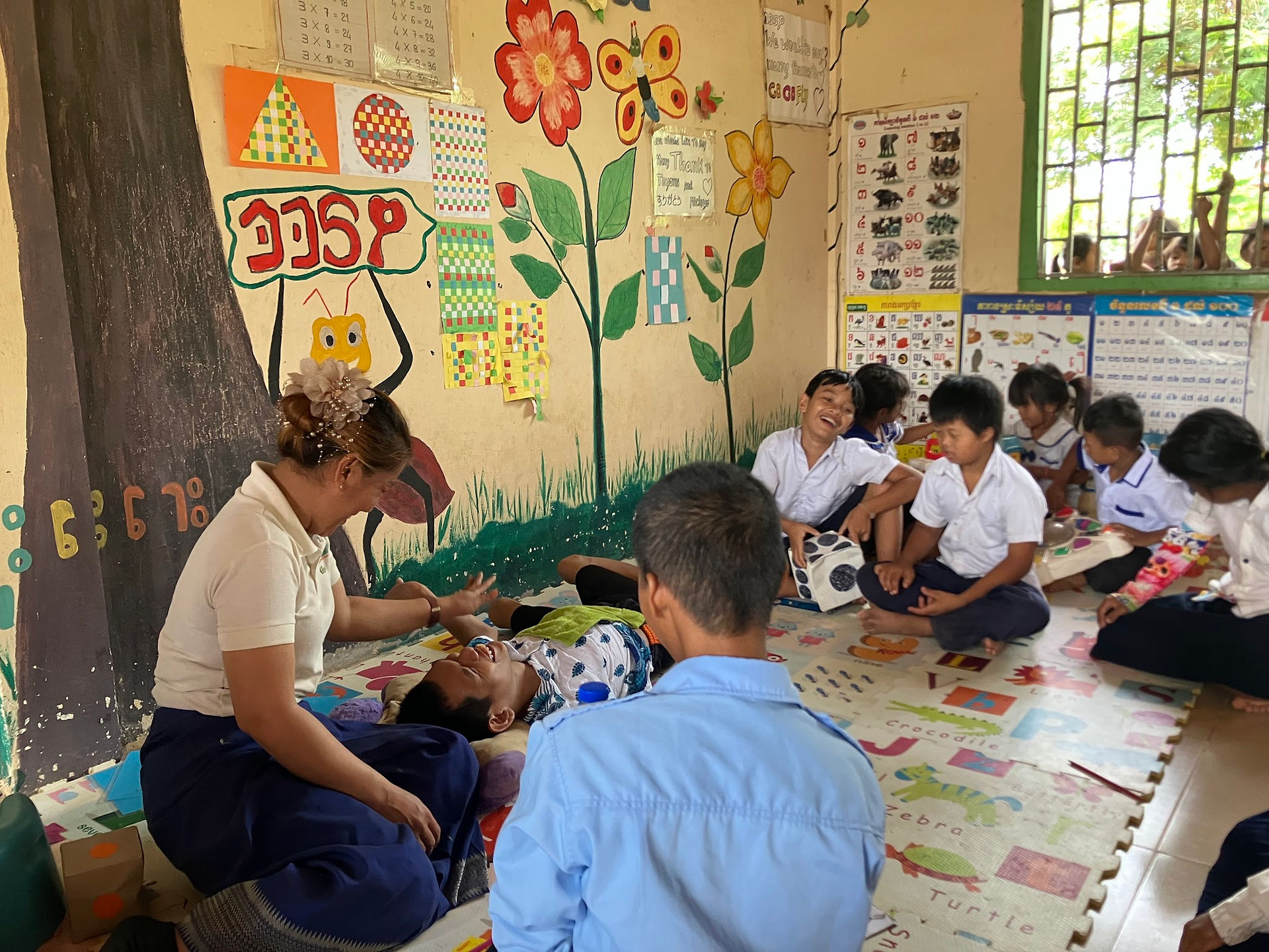DDSP students in a classroom seated on the floor with a teacher