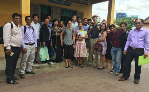 DSI cohort of Cambodian trainees standing outside in front of local school