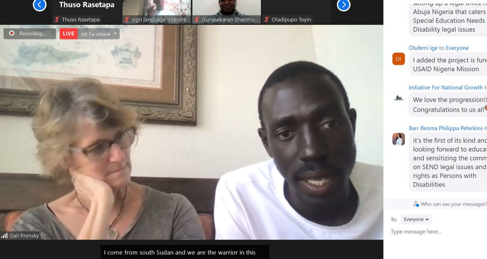 Zoom screen capture of man from South Sudan speaking to online participants seated next to white woman listening