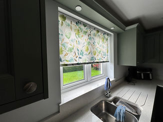 A patterned roller blind on a small window
