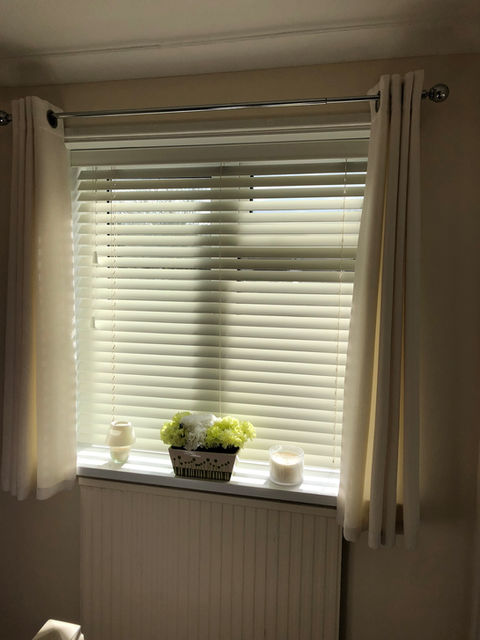 Venetian blind behind a curtain