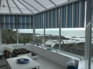 New roller blinds in a conservatory overlooking a bay