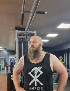 Kunde im Fitnessstudio trägt ärmelloses Shirt mit Runen und Yggdrasil