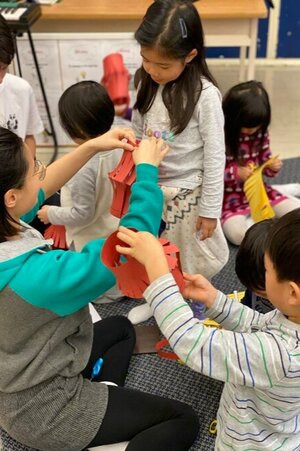 Chinese language teacher helps student.