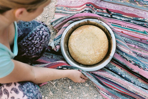 Systemic nature therapy retreat in the desert in Egypt, El Gouna, home-baked bread from the fireplace with colorful carpet in the background