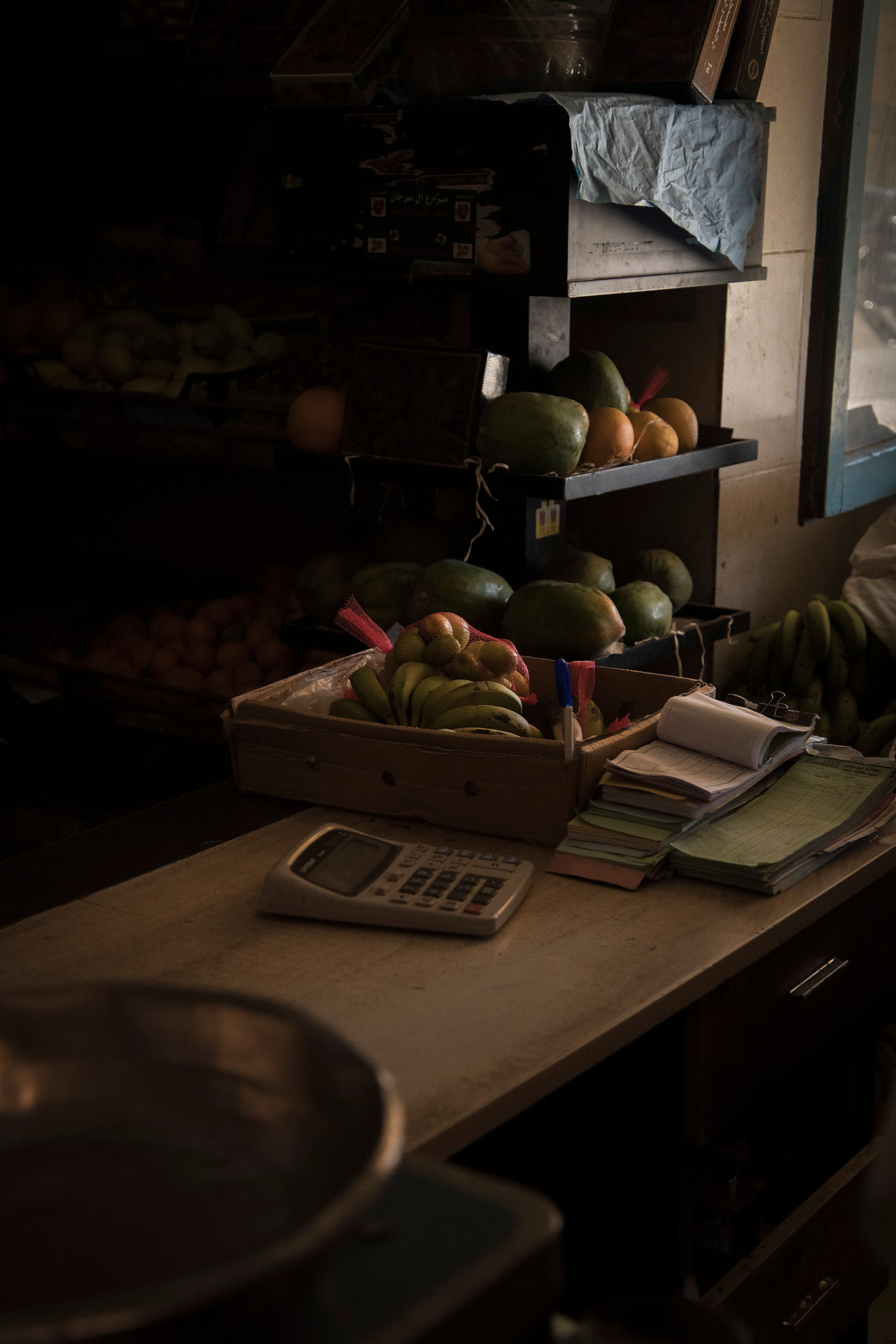 Systemic Naturetherapy Retreat in the Desert in Egypt, El Gouna, small table with calculator, notes and a fruit bowl and vegetable boxes in the background
