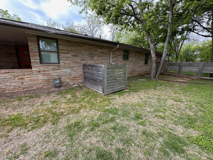 Side of house with only grass and no pathway connecting the front to the back of the property.