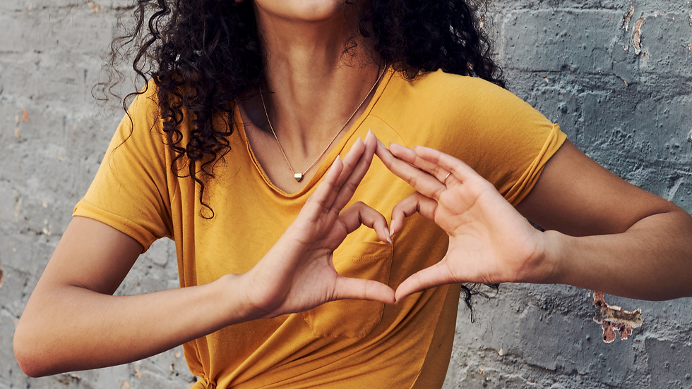 Frau formt mit ihren Händen ein Herz.
