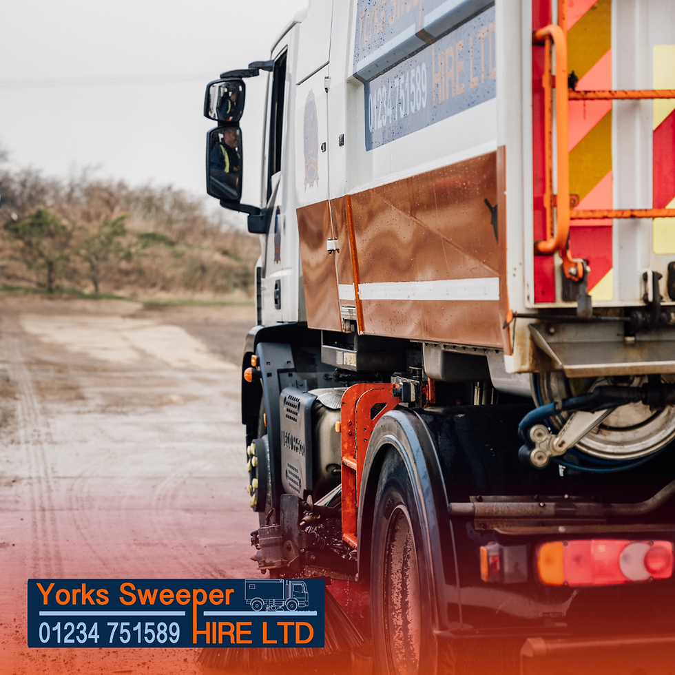 A white and orange street sweeper truck on a dirt road. Overcast sky. Visible text: "Yorks Sweeper HIRE LTD 01234 751589".